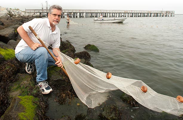 Tim Targett on oceanside riprap with net