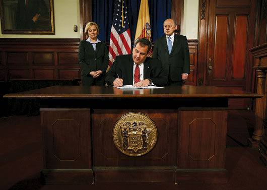 Christie at desk signing bill