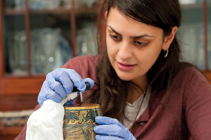 Woman works on a vase at Auburn Heights