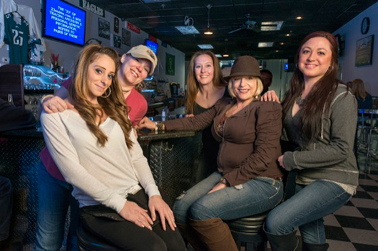 Barbara Tullio (with brown hat) is surrounded by employees at her pub, McTullio's, in northern Delaware.