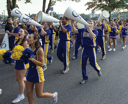 The football team is led in a spirited march to Delaware Stadium.