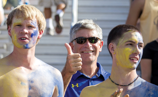 UD President Patrick T. Harker with students at football game