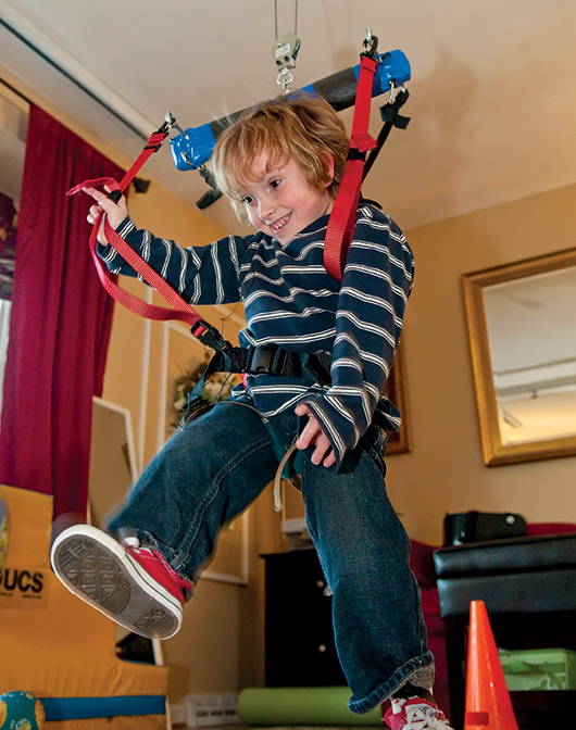 Andrew using harness to kick a ball