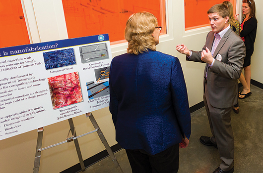 Visitors talk with students and researchers outside the Nanofabrication Facility's state-of-the-art clean room.