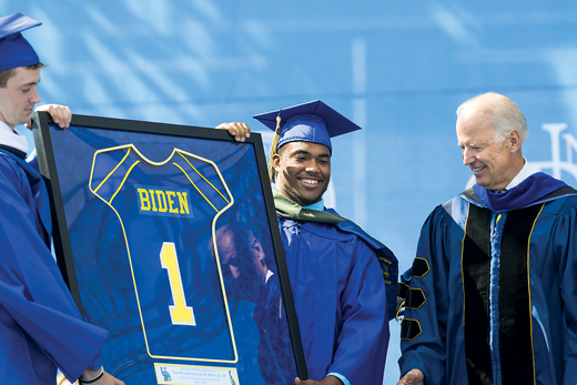 Joe Biden receiving a football jersey at Commencement