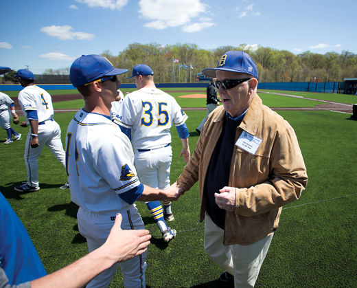 Bob Hannah shaking hands with current UD baseball players