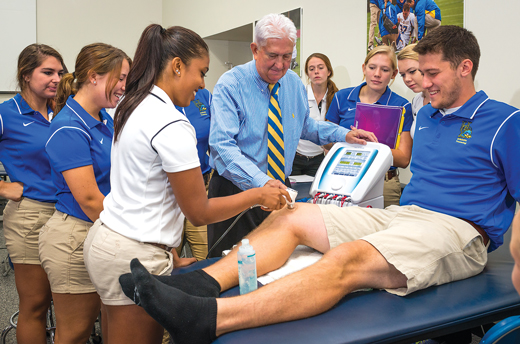 Keith Handling shows athletic training students how to work on an injured knee