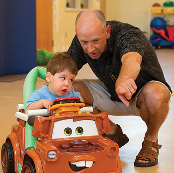 Cole Galloway with child using GoBabyGo car