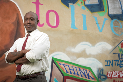 Yasser Payne in front of a mural in Wilmington, DE