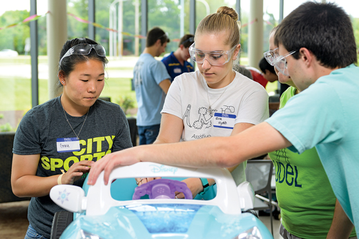 students from the assistive medical technologies club work on a GoBabyGo car