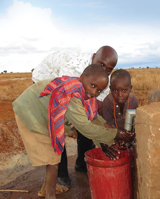A man and two children in Kenya getting water